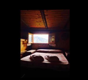 ein Schlafzimmer mit einem großen Bett mit Fenster in der Unterkunft DOSSENA Splendido Chalet di Montagna immerso nella natura in Madonna della Costa