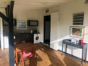 a living room with a table and a washing machine at Agréable appartement à 2 pas des plages in Le Gosier