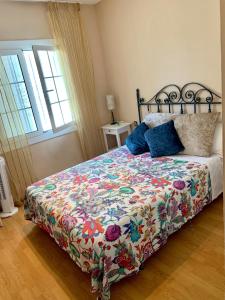 a bedroom with a bed with a floral comforter at Apartamento Altafulla in Altafulla