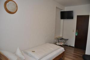ein kleines Schlafzimmer mit einem Bett und einem Spiegel in der Unterkunft Steakhaus Büffel Hotel Restaurant in Heimbach