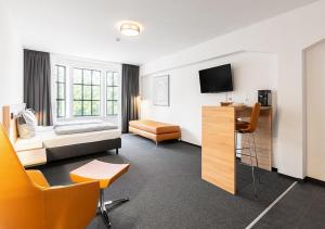 a hotel room with a bed and a tv at Apartimo Landshut in Landshut