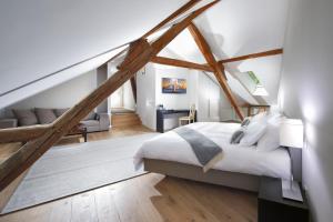 a bedroom with a white bed and a loft at La Ferme du Château in Lucens