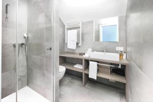 a bathroom with a shower and a toilet and a sink at La Ferme du Château in Lucens