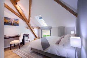 um quarto com uma cama, uma secretária e uma mesa em La Ferme du Château em Lucens