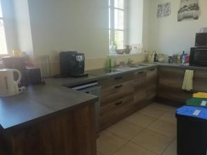 - une cuisine avec des placards en bois et un comptoir dans l'établissement L'auberge de Treigny, à Treigny