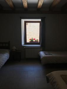 a room with two beds and a window with red flowers at Albergue Orion in Castrojeriz