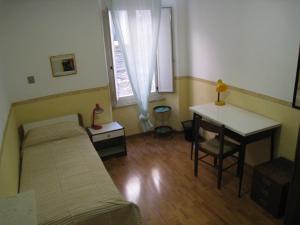 1 dormitorio con cama, escritorio y ventana en Casa Mariotti, en Perugia