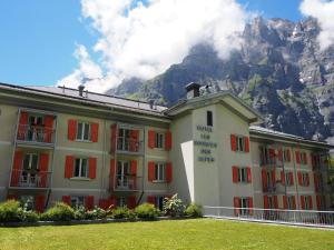 a building with a mountain in the background at Hôtel Les Sources des Alpes in Leukerbad