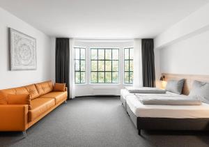1 dormitorio con 2 camas, sofá y ventana en Apartimo Landshut, en Landshut