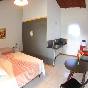 1 dormitorio con 1 cama y lavamanos en una habitación en Suites Vida Mansa en Maresias
