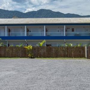 a white building with a fence in front of it at Suites Vida Mansa in Maresias