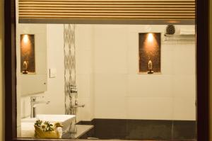 a bathroom with a sink, mirror, and bath tub at Hill House Manali -A home in mountains in Manāli
