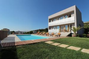 a villa with a swimming pool in front of a house at Vila Nainer in Pag