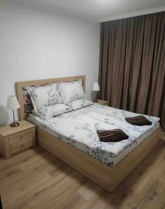 a bedroom with a bed with two night stands and a window at Amazing apartment facing the sea in Burgas City