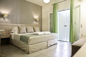 a bedroom with a large bed with green curtains at Ikion Eco Boutique Hotel in Patitiri