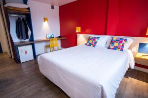 Schlafzimmer mit einem großen weißen Bett und einer roten Wand in der Unterkunft ibis Styles Campina Grande in Campina Grande