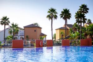 a view of a swimming pool with palm trees at Aldiana Club Costa del Sol in La Alcaidesa