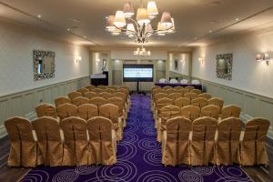 a room with a row of chairs and a screen at Woodford Dolmen Hotel Carlow in Carlow