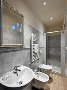 ein Badezimmer mit einem Waschbecken, einem WC und einem Spiegel in der Unterkunft B&B Dei Rossi in Siena