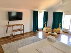 a living room with a couch and a tv at Casa Mediterana in 2 Mai