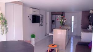a living room with a table and a kitchen at T2 climatisé baignoire terrasse Jacuzzi Piscine Sauna in Launaguet