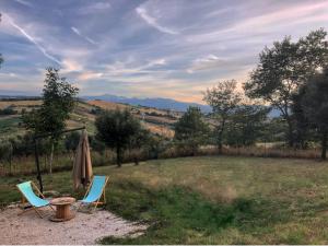 two chairs and a table and an umbrella in a field at Casa Sofì in Tolentino