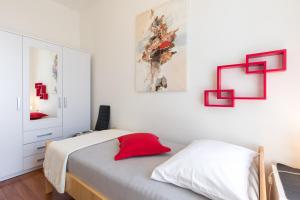 Apartment Tessa في رييكا: غرفة نوم بسرير ومخدة حمراء