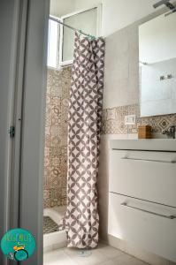 Baño con cortina de ducha junto a una ventana en BICIaMICI Apartments, en Scafati