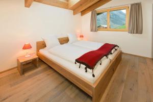 a bedroom with a bed with a red blanket on it at Casa Della Vita by Zermatt Premium Apartments in Zermatt