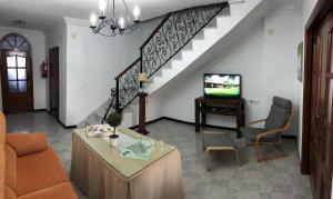 uma sala de estar com um sofá e uma televisão e escadas em CASA MARIA LUISA em El Bosque