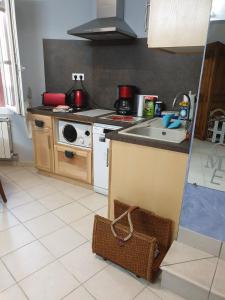 a kitchen with a sink and a stove top oven at Chambre d'hôtes Esterelle in Pernes-les-Fontaines