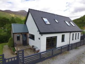 a white house with a black roof at Hawthorn Cottage in Glencoe