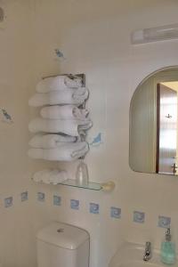 uma casa de banho com uma pilha de toalhas numa prateleira em Stone House Farm em St Bees