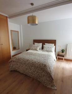 una camera da letto bianca con un letto grande e uno specchio di Corazón Gótico VUT-09-201 a Burgos