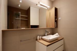 伊齐齐MODENA MARIS-heated pool-grill-relax-jacuzzi apartments的带水槽和镜子的浴室