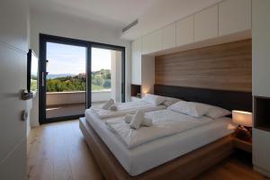 伊齐齐MODENA MARIS-heated pool-grill-relax-jacuzzi apartments的一间带大床和大窗户的卧室