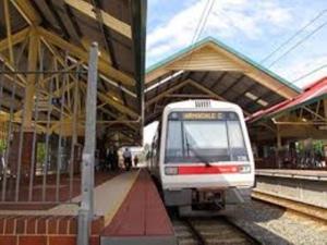 a white train pulling into a train station at Near Train Station in Perth