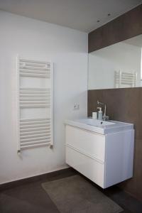 a white bathroom with a sink and a window at Rifugio Ibleo in Ragusa