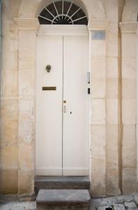 ラグーザにあるRifugio Ibleoの石壁の建物内白い扉