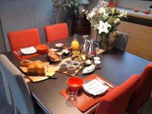 a table with food on it with orange chairs at Le Temps d'une Pause in Bretignolles-sur-Mer +40 photos