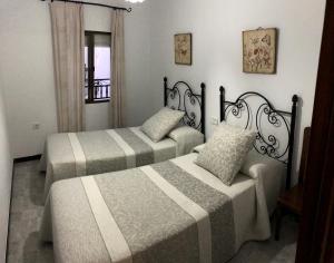 sypialnia z dwoma łóżkami i oknem w obiekcie CASA MARIA LUISA w mieście El Bosque
