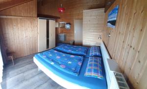 uma cama grande num quarto com paredes de madeira em Ferienhaus Waidmanns-Heil em Höchenschwand