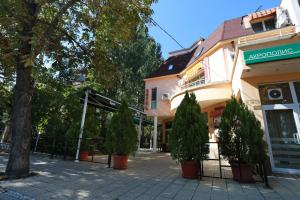 a street with trees in front of a building at Acropolis Hotel in Pazardzhik