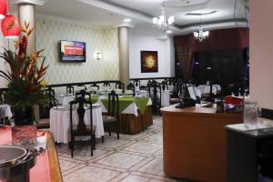 a restaurant with tables and chairs in a room at Hotel Puerta del Sol in David