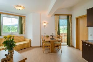 ein Wohnzimmer mit einem Tisch und einem Sofa in der Unterkunft Landhotel Hubengut Bed and Breakfast in Radstadt