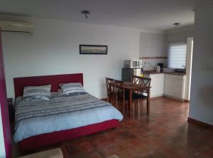 1 dormitorio con cama, mesa y cocina en Studios with beautiful sea view, en Willemstad