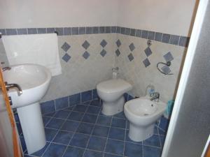 a blue tiled bathroom with a sink and a toilet at Casa Vacanze Caccamo Santa Lucia in Caccamo +31 photos