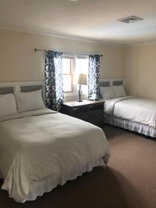 A bed or beds in a room at Boardwalk Beach Inn