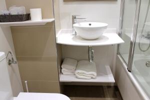a bathroom with a sink and a shower and towels at Hotel Restaurante Santos in Santomera +16 photos