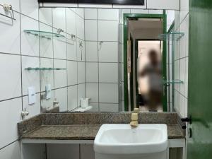 a bathroom with a sink and a mirror at Porto de Iracema - Iracema Imoveis in Fortaleza